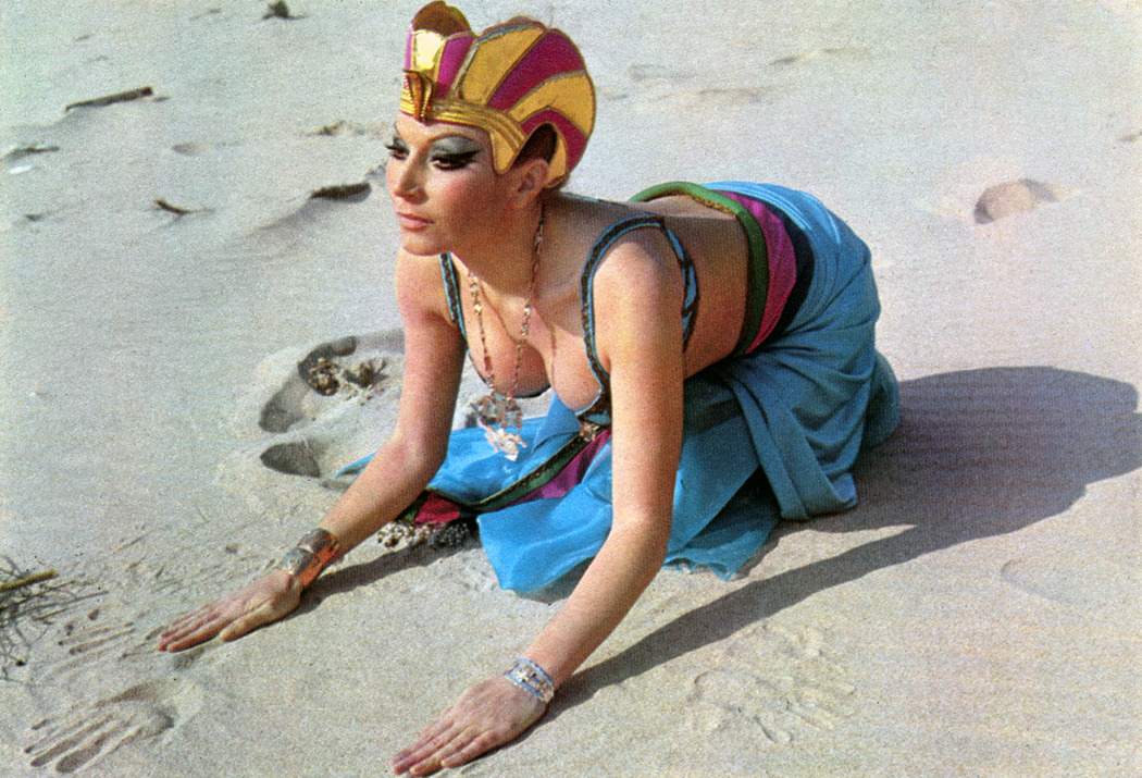 Cleopatra-Jurado, sobre la arena, imita la postura de la Esfinge.