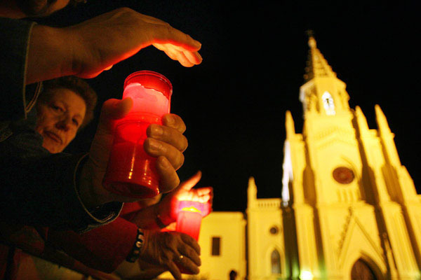 Los chipioneros, con velas en las manos, esperan la llegada del féretro de Rocío Jurado
