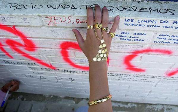 Una mujer lee los pésames escritos en una pared junto al domicilio de Rocío Jurado